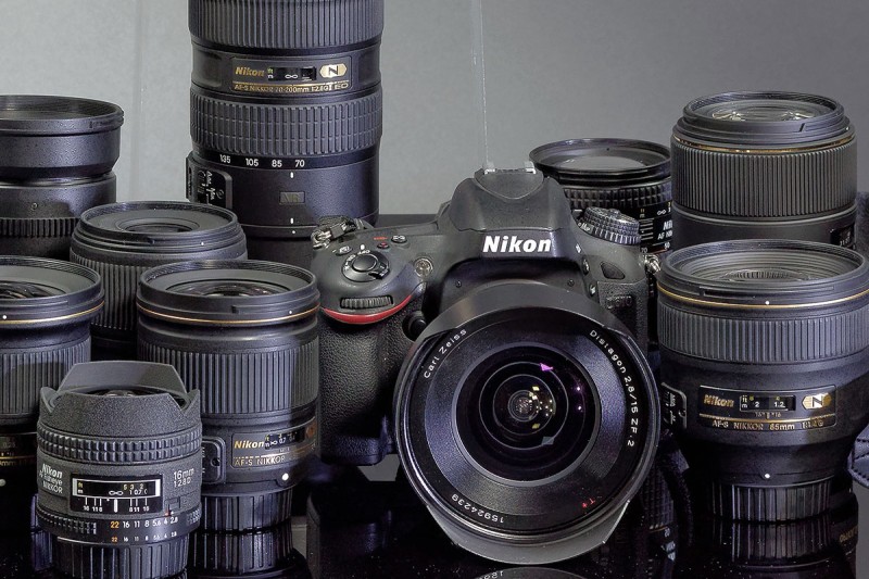 photo of a camera surrounded by numerous lenses to illustrate the equipment